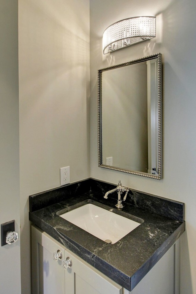 Aménagement d'un grand WC et toilettes classique avec un placard à porte shaker, des portes de placard grises, un carrelage gris, des carreaux de béton, un mur blanc, un lavabo encastré et un plan de toilette en marbre.