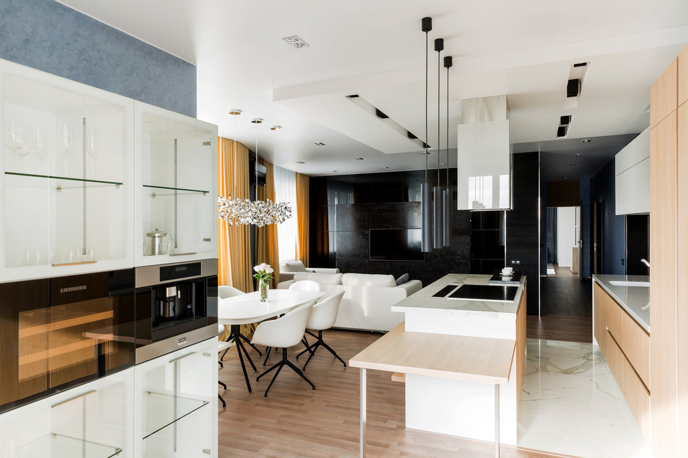 Mid-sized contemporary u-shaped open plan kitchen in Other with flat-panel cabinets, white cabinets, granite benchtops, white splashback, porcelain splashback, with island, white floor and white benchtop.