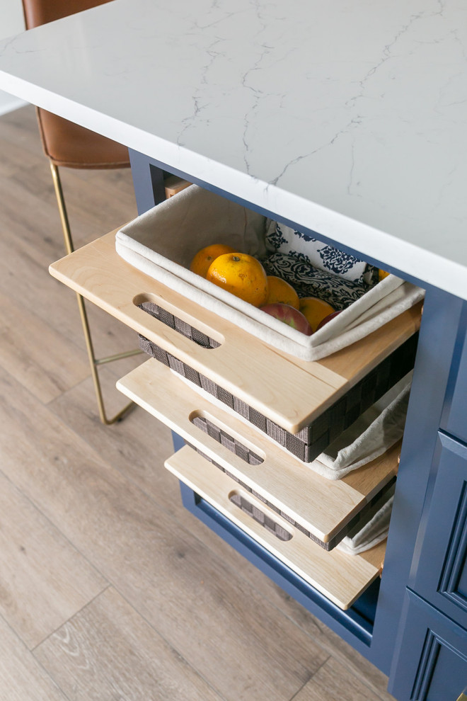 Kitchen pantry - large transitional l-shaped brown floor kitchen pantry idea in Baltimore with a drop-in sink, shaker cabinets, white cabinets, quartz countertops, white backsplash, ceramic backsplash, stainless steel appliances, an island and white countertops