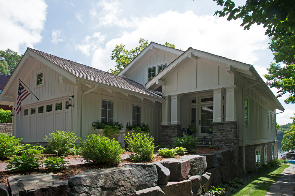 Photo of a mid-sized contemporary two-storey white house exterior in Minneapolis with wood siding and a shingle roof.