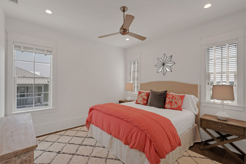 Photo of a mid-sized traditional guest bedroom in Miami with white walls, medium hardwood floors, no fireplace and brown floor.