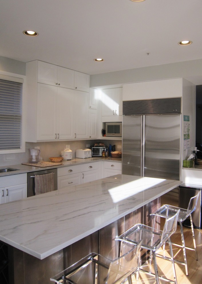 Eat-in kitchen - transitional light wood floor eat-in kitchen idea in Chicago with raised-panel cabinets, white cabinets, marble countertops, subway tile backsplash, an island and stainless steel appliances