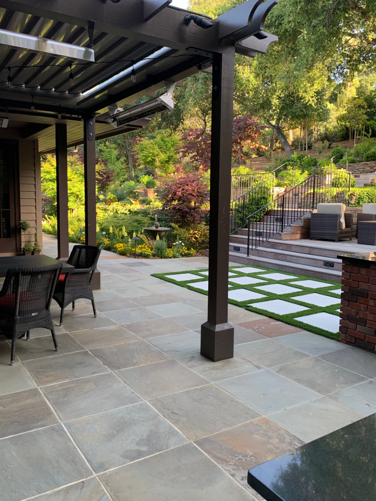 This is an example of a large arts and crafts front yard full sun driveway in San Francisco with a retaining wall and natural stone pavers.