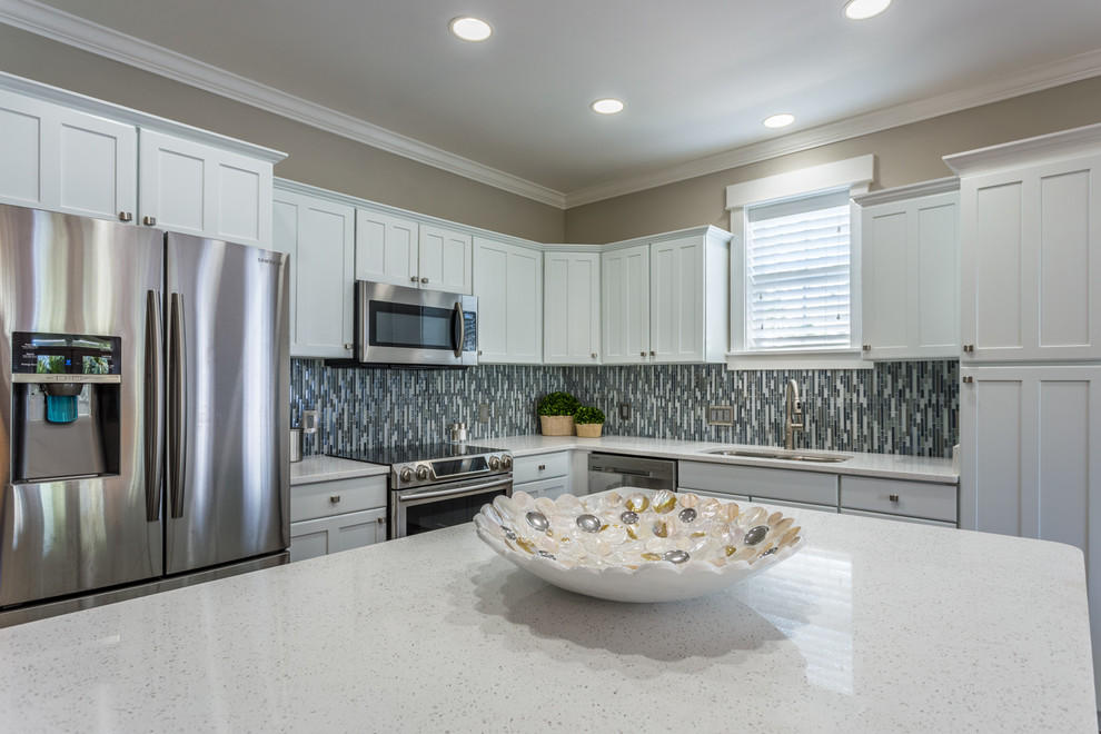 Example of a mid-sized transitional l-shaped dark wood floor and brown floor open concept kitchen design in Miami with an undermount sink, shaker cabinets, white cabinets, quartz countertops, multicolored backsplash, mosaic tile backsplash, stainless steel appliances and an island