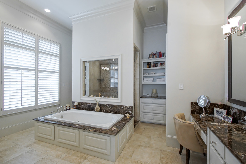 Photo of a mid-sized transitional master bathroom in New Orleans with an undermount sink, raised-panel cabinets, white cabinets, marble benchtops, a drop-in tub, an open shower, a one-piece toilet, porcelain tile, white walls and porcelain floors.