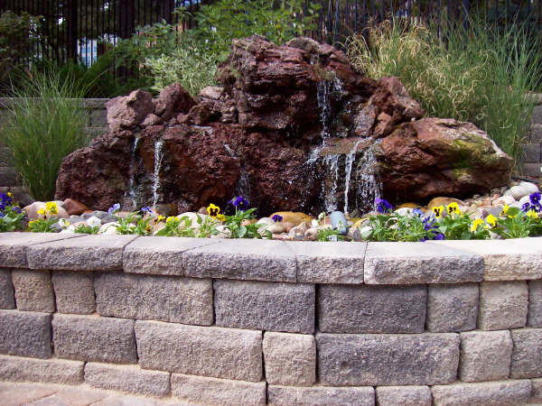 This is an example of a mid-sized asian backyard garden in Denver with a water feature and natural stone pavers.
