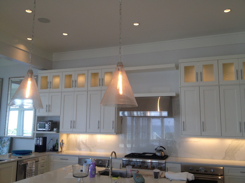Large beach style kitchen in Miami with stone slab splashback and with island.