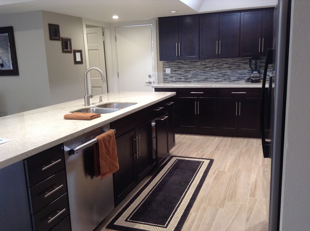 Inspiration for a mid-sized transitional u-shaped light wood floor eat-in kitchen remodel in Phoenix with a double-bowl sink, raised-panel cabinets, black cabinets, granite countertops, white backsplash, subway tile backsplash, stainless steel appliances and no island