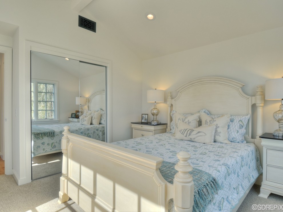 Small beach style guest bedroom in San Diego with white walls and carpet.