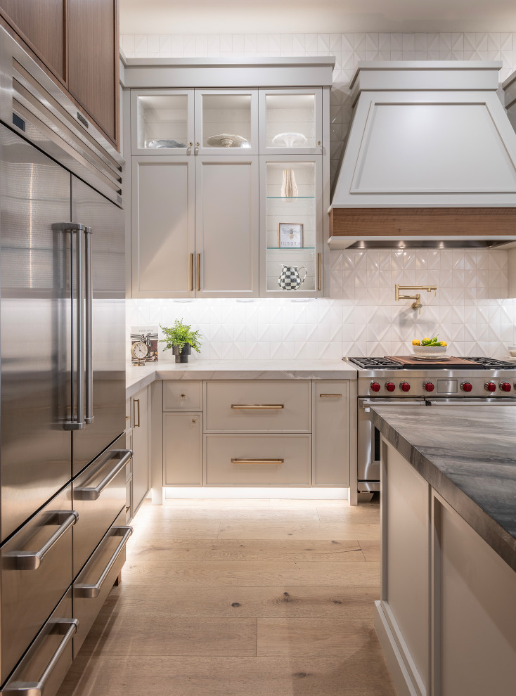 Mid-sized transitional medium tone wood floor and beige floor kitchen photo in Phoenix with a double-bowl sink, recessed-panel cabinets, quartzite countertops and an island
