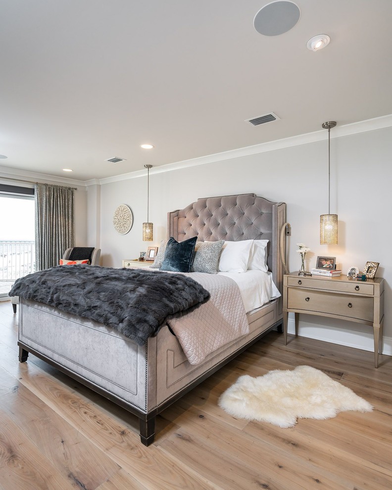 Transitional bedroom in Other with grey walls and light hardwood floors.