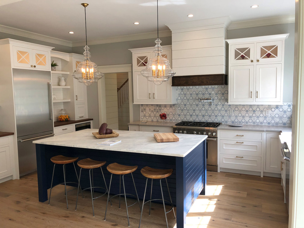 Inspiration for a mid-sized transitional u-shaped eat-in kitchen in Boston with a farmhouse sink, beaded inset cabinets, white cabinets, quartz benchtops, stainless steel appliances, medium hardwood floors, with island, brown floor and grey benchtop.