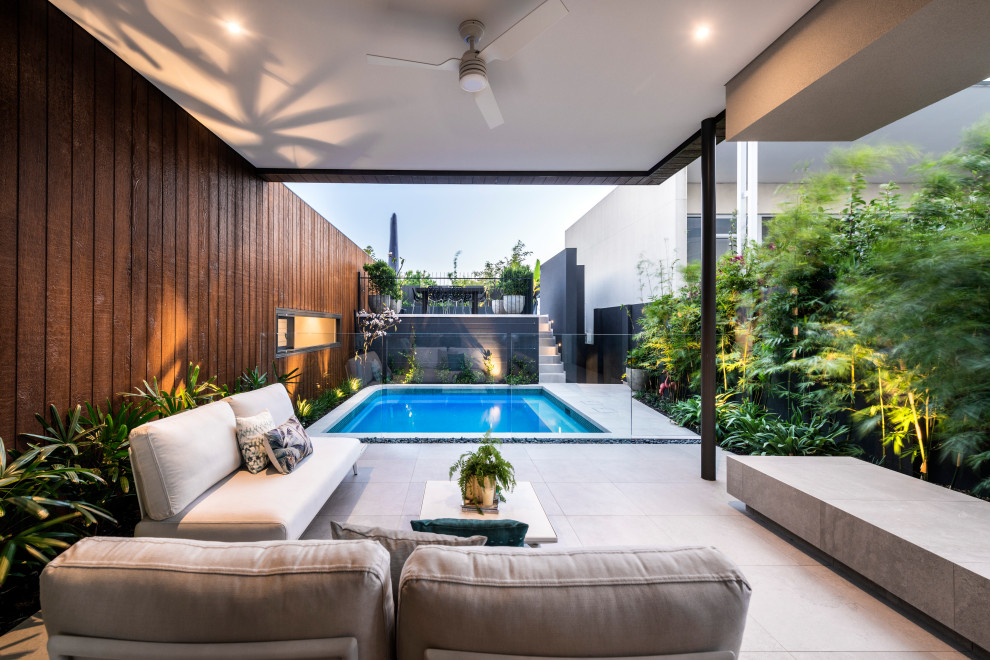 Photo of a mid-sized contemporary backyard patio in Perth with a roof extension.