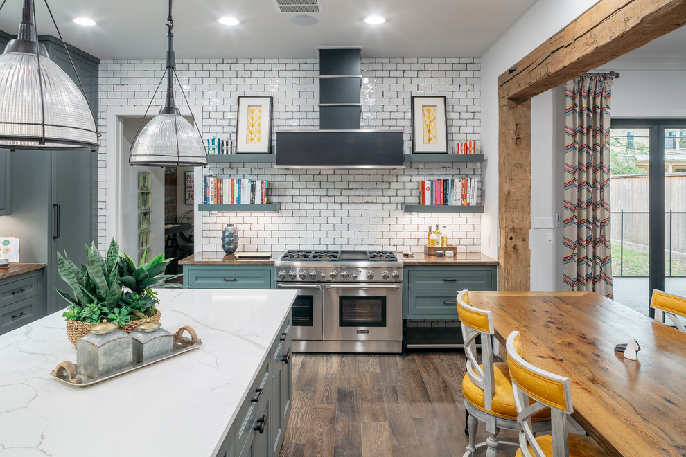 This is an example of a large transitional u-shaped eat-in kitchen in Houston with grey cabinets, white splashback, subway tile splashback, stainless steel appliances, with island, brown floor, recessed-panel cabinets, dark hardwood floors, marble benchtops and brown benchtop.