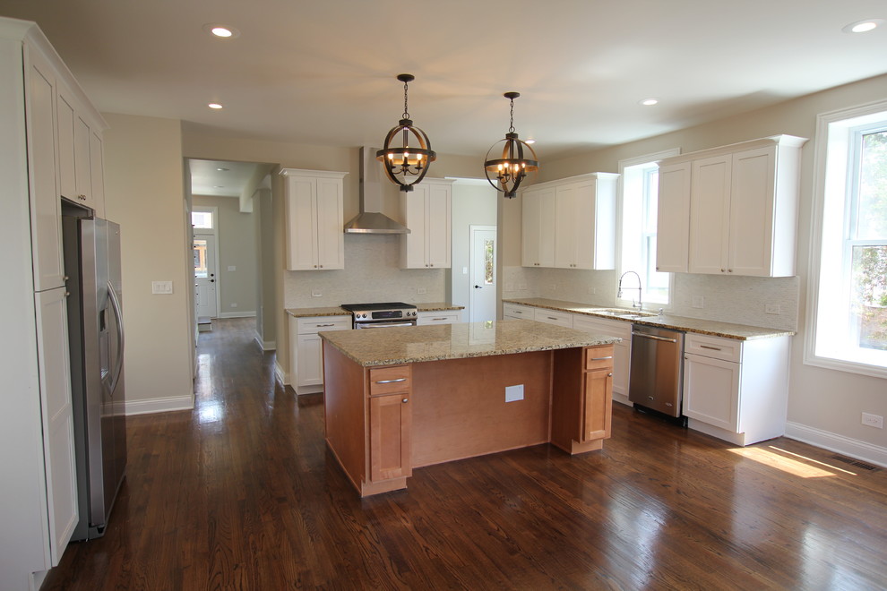 Large transitional u-shaped medium tone wood floor open concept kitchen photo in Chicago with an undermount sink, shaker cabinets, white cabinets, granite countertops, gray backsplash, stone tile backsplash, stainless steel appliances, gray walls and an island