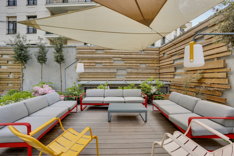 Exemple d'un grand jardin arrière tendance au printemps avec une exposition partiellement ombragée, une terrasse en bois et une clôture en bois.