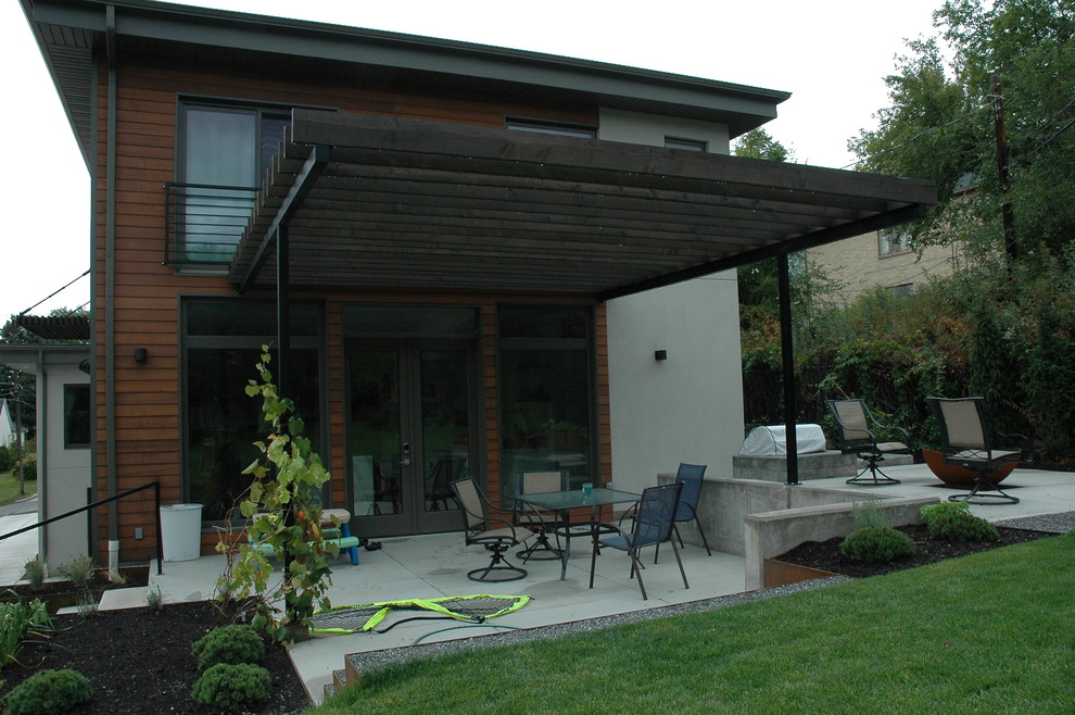 Photo of a mid-sized modern backyard patio in Salt Lake City with concrete pavers, a fire feature and a pergola.