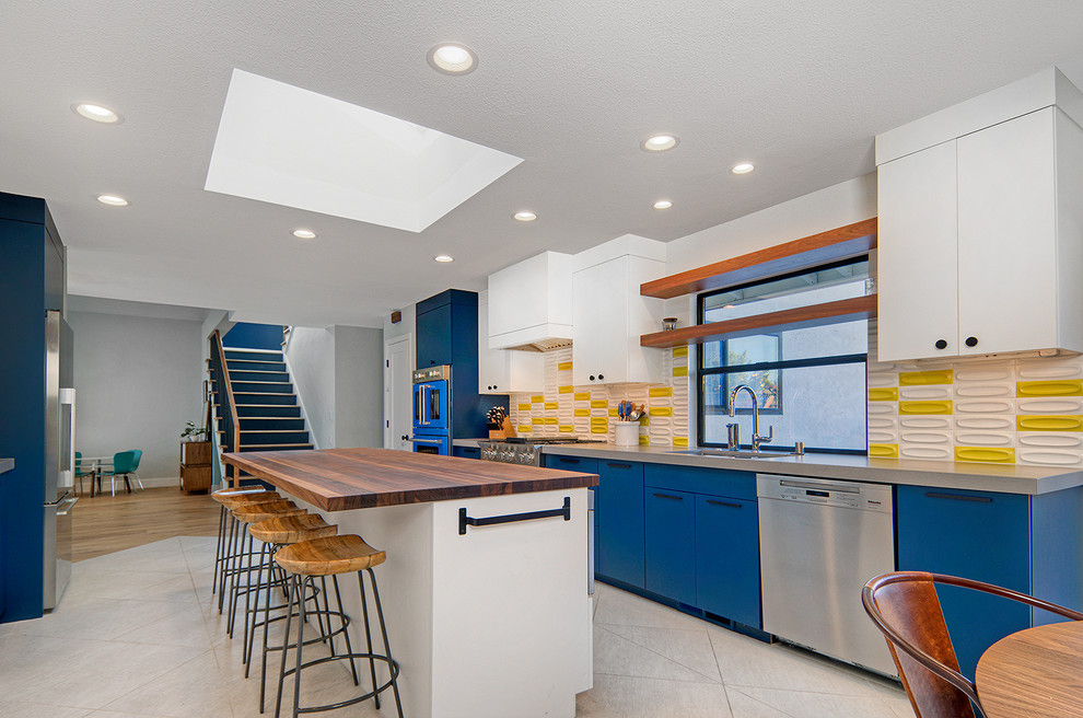 This is an example of a mid-sized midcentury galley eat-in kitchen in San Francisco with an undermount sink, flat-panel cabinets, blue cabinets, quartz benchtops, yellow splashback, ceramic splashback, coloured appliances, ceramic floors, with island, grey floor and grey benchtop.