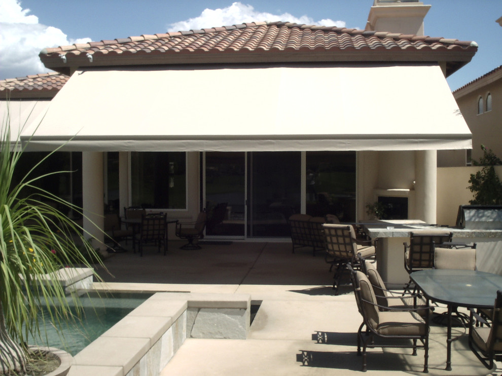 Photo of a large mediterranean backyard patio in Chicago with a water feature, concrete pavers and an awning.