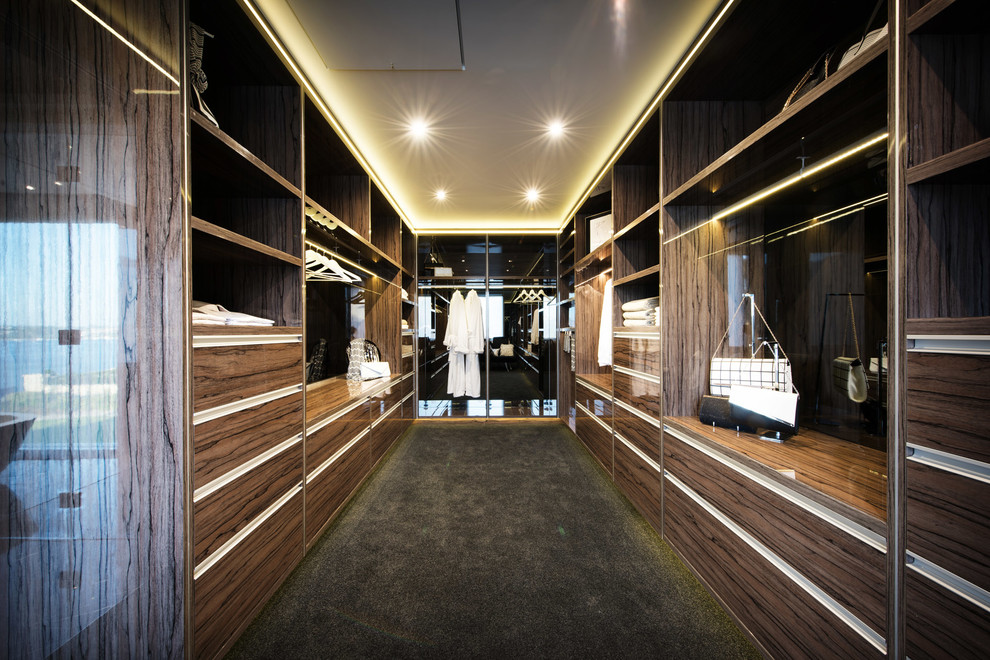 Photo of a large contemporary storage and wardrobe in Perth with dark wood cabinets and black floor.