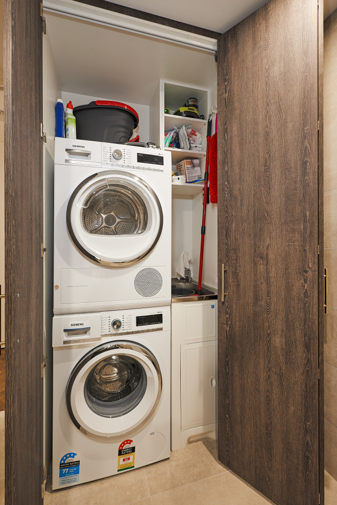 Inspiration for a modern laundry room in Melbourne with brown cabinets, porcelain floors and beige floor.