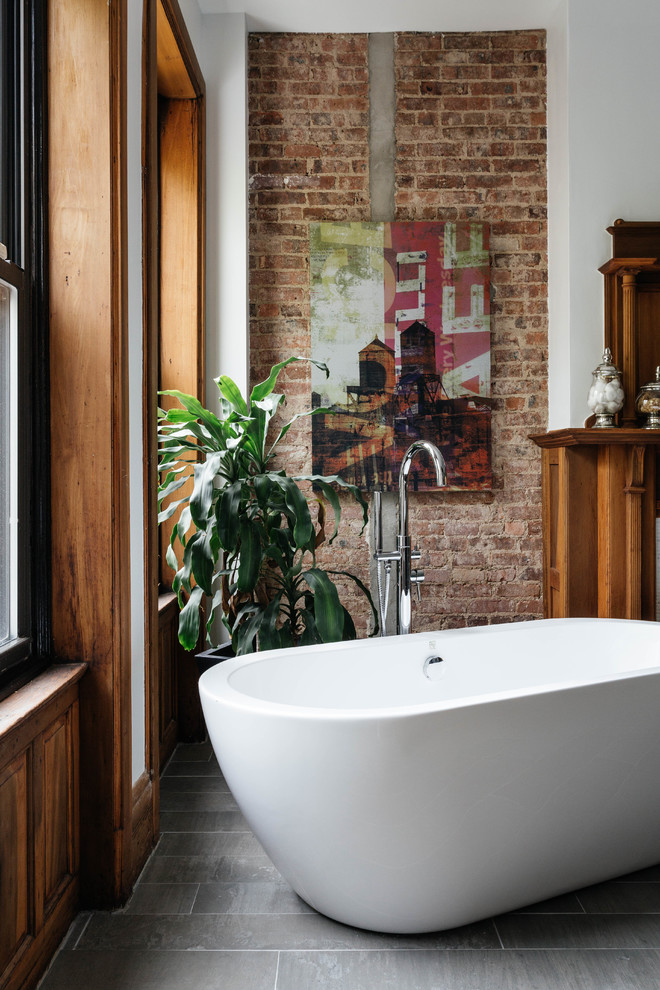 Design ideas for a transitional master bathroom in New York with a freestanding tub and concrete floors.