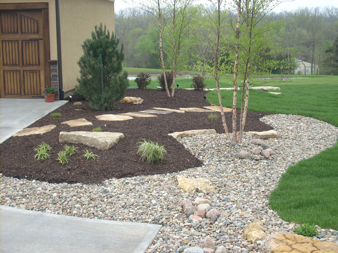 This is an example of a small front yard full sun formal garden in Kansas City with mulch.