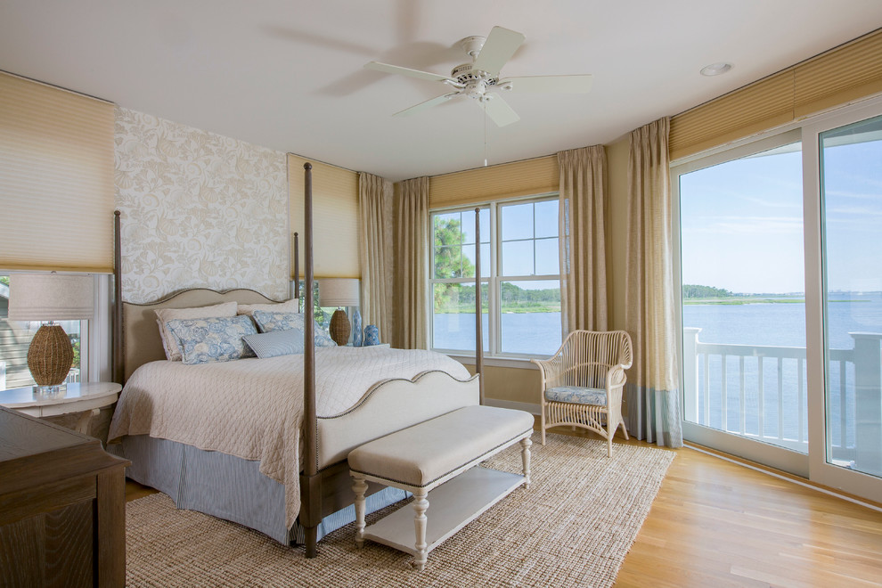 Design ideas for a large beach style master bedroom in Baltimore with beige walls, light hardwood floors, no fireplace and brown floor.