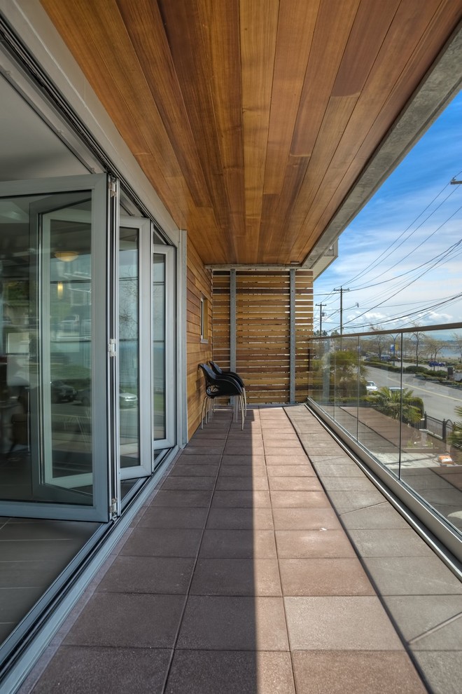 This is an example of a modern balcony in Vancouver with a roof extension.