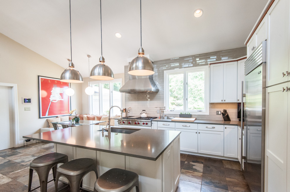 Photo of a large contemporary l-shaped eat-in kitchen in DC Metro with an undermount sink, shaker cabinets, white cabinets, quartz benchtops, grey splashback, glass tile splashback, stainless steel appliances, slate floors, with island, multi-coloured floor and grey benchtop.