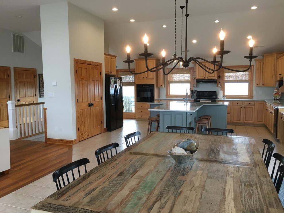 Example of a large beach style cement tile floor eat-in kitchen design with an undermount sink, medium tone wood cabinets, quartzite countertops, stainless steel appliances and an island