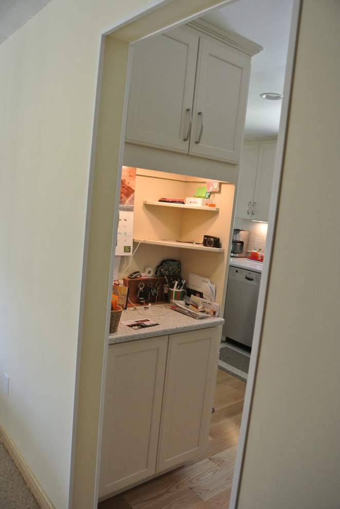Transitional l-shaped medium tone wood floor eat-in kitchen photo in Boston with an undermount sink, shaker cabinets, white cabinets, recycled glass countertops, white backsplash, subway tile backsplash, stainless steel appliances, a peninsula and white countertops