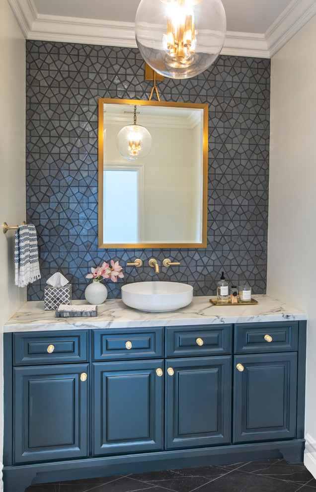 This is an example of a mid-sized transitional 3/4 bathroom in Los Angeles with raised-panel cabinets, blue cabinets, ceramic tile, black walls, limestone floors, a vessel sink, marble benchtops, black floor and white benchtops.