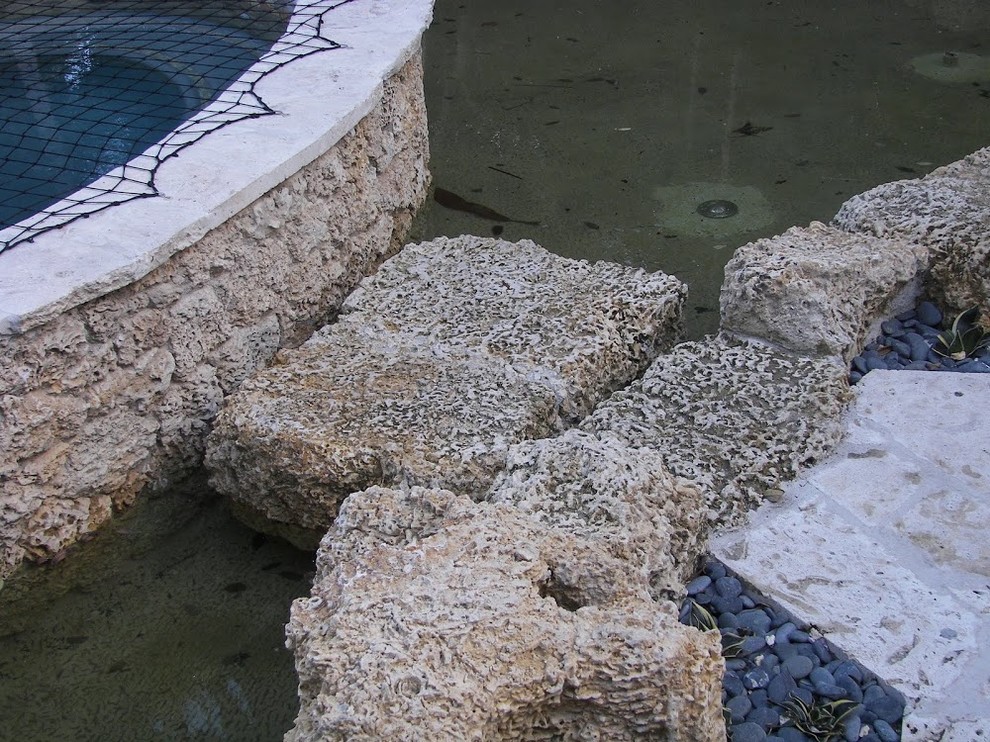 Pool fountain - transitional backyard stone and custom-shaped aboveground pool fountain idea in Miami