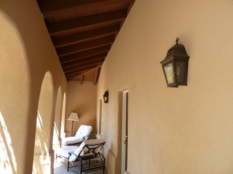 This is an example of a mid-sized mediterranean backyard patio in Phoenix with a roof extension.