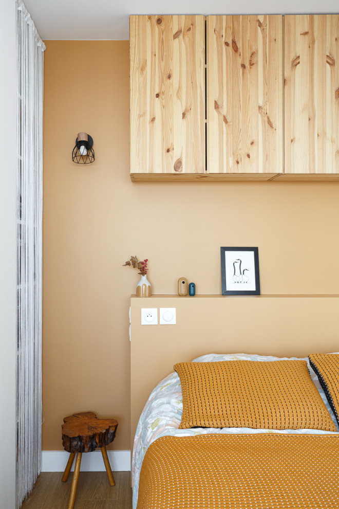 Imagen de dormitorio principal escandinavo pequeño con parades naranjas y suelo de madera en tonos medios