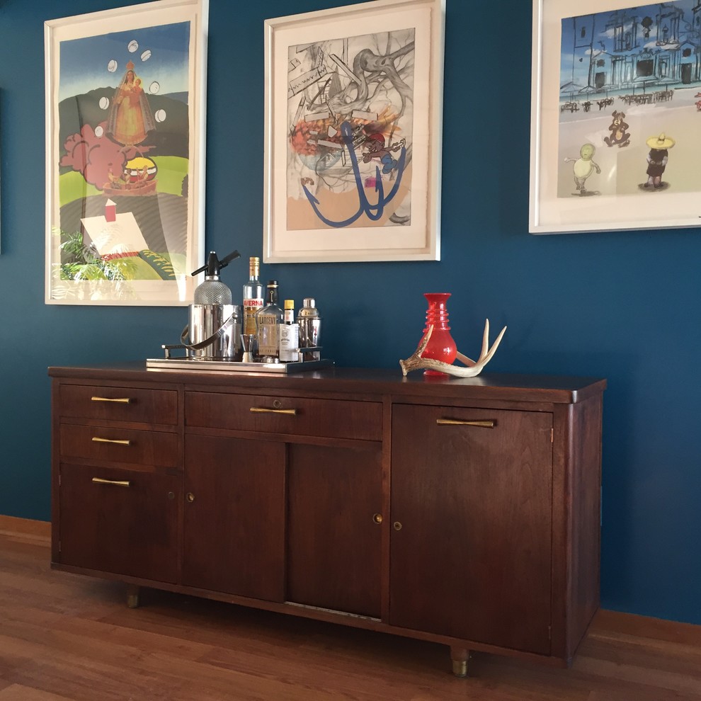 Mid-sized midcentury single-wall home bar in Other with dark wood cabinets, wood benchtops, laminate floors, brown benchtop and brown floor.