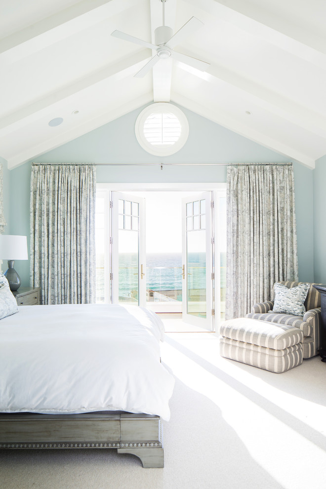 This is an example of a beach style bedroom in Orange County with blue walls, carpet and beige floor.