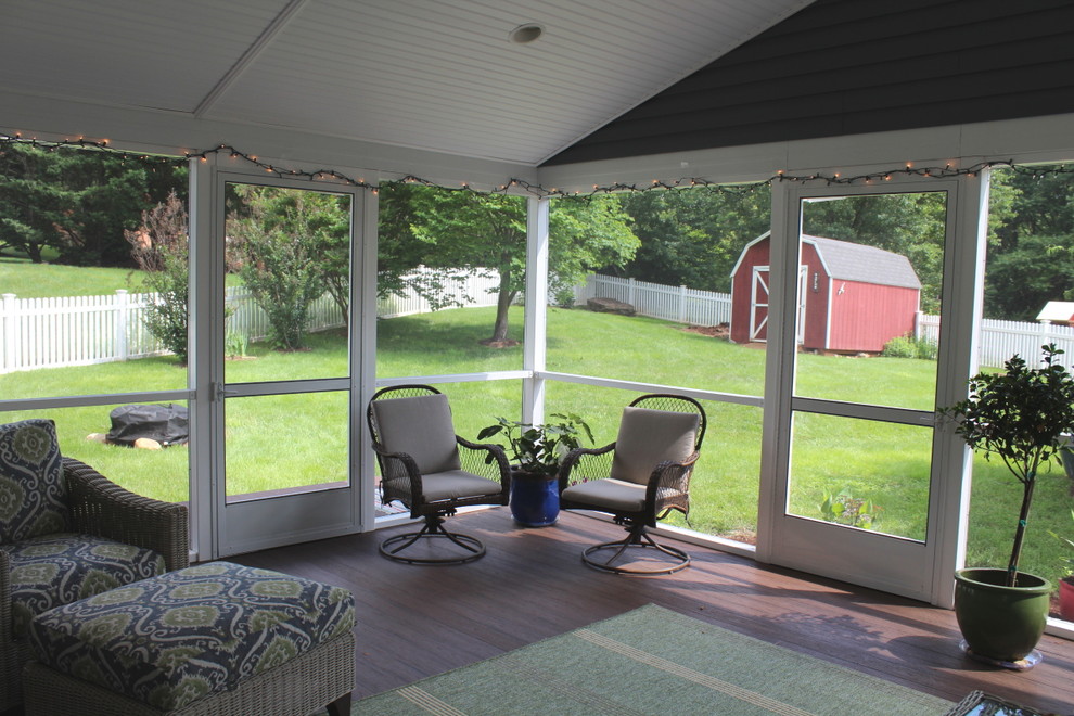 Photo of a mid-sized traditional backyard screened-in verandah in Other with decking and a roof extension.
