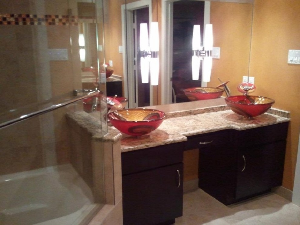 This is an example of a contemporary bathroom in Dallas with a vessel sink, dark wood cabinets, granite benchtops, a corner shower and yellow walls.