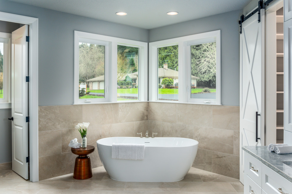 Photo of a large transitional master bathroom in Portland with open cabinets, white cabinets, a freestanding tub, gray tile, porcelain tile, grey walls, porcelain floors, an undermount sink, engineered quartz benchtops, grey floor and grey benchtops.