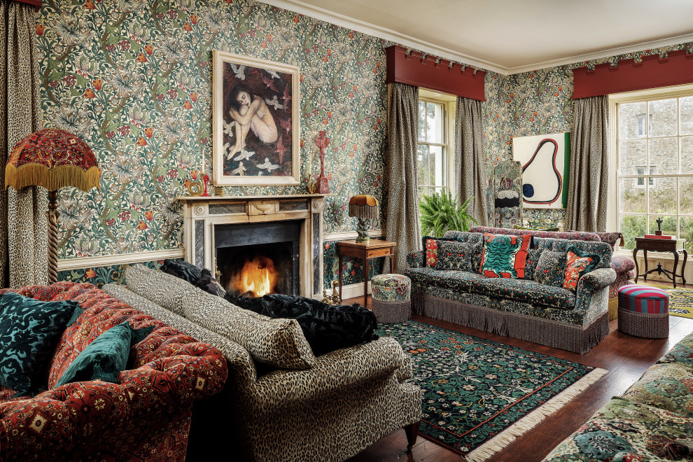 This is an example of a large bohemian enclosed living room in Cornwall with multi-coloured walls, dark hardwood flooring, a standard fireplace and a wallpapered ceiling.