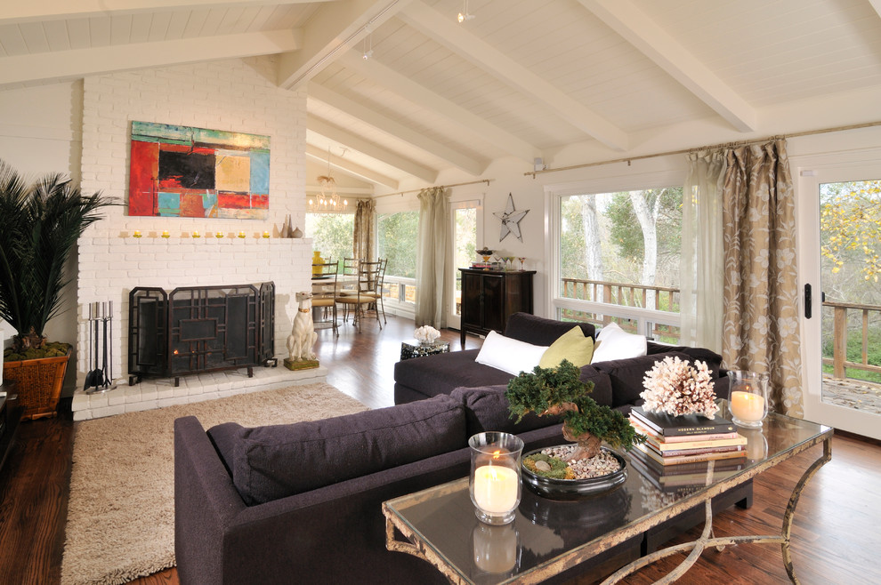 This is an example of a mid-sized midcentury formal open concept living room in Other with white walls, a brick fireplace surround, a standard fireplace and medium hardwood floors.