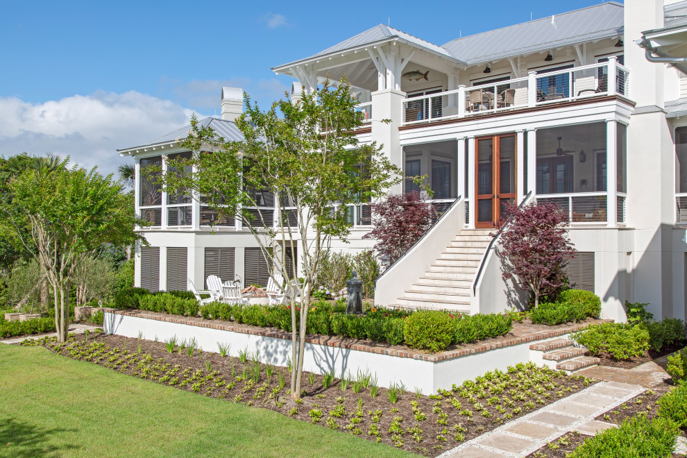 Immagine della villa grande bianca stile marinaro a tre piani con rivestimento in stucco, tetto a padiglione, copertura in metallo o lamiera, tetto grigio e pannelli sovrapposti