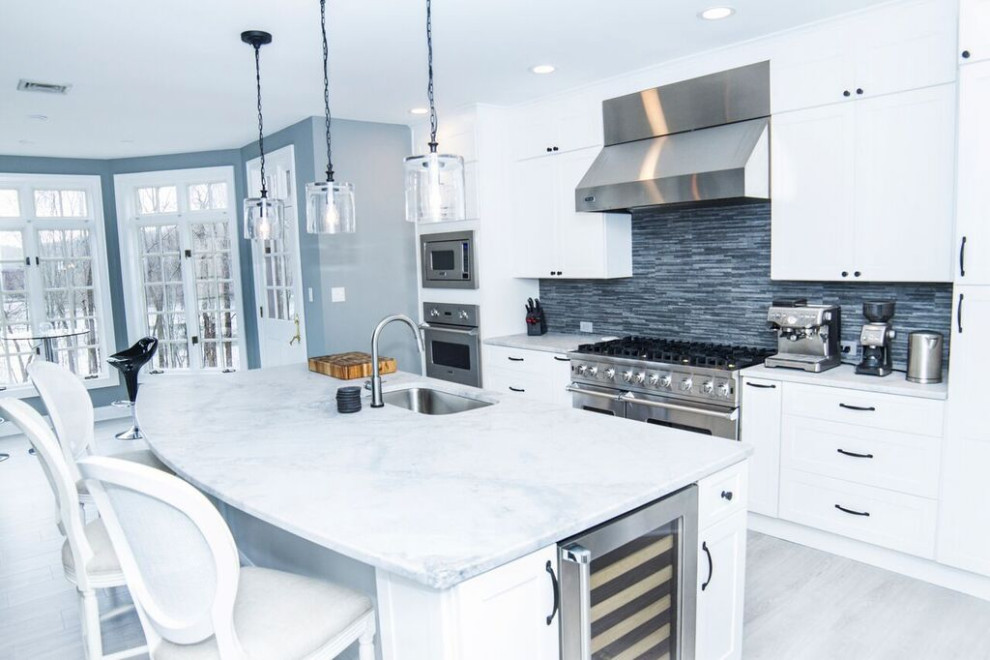 Inspiration for a large transitional u-shaped eat-in kitchen in Philadelphia with an undermount sink, shaker cabinets, white cabinets, quartzite benchtops, blue splashback, porcelain splashback, white appliances, vinyl floors, with island and yellow benchtop.