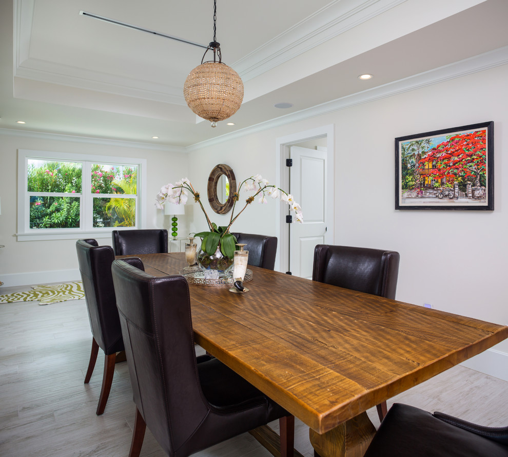 Photo of a mid-sized contemporary dining room in Miami with beige walls, light hardwood floors and no fireplace.