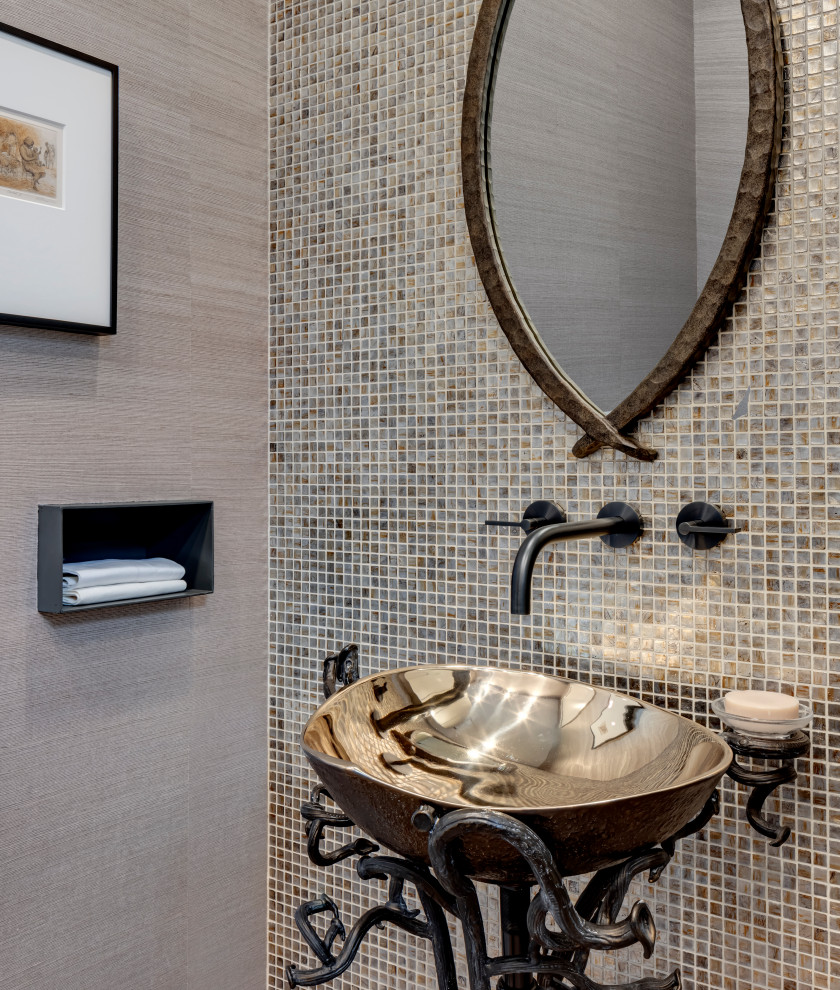 Photo of a modern powder room in Dallas with a one-piece toilet, multi-coloured tile, mosaic tile, grey walls, medium hardwood floors, a pedestal sink, brown floor, a freestanding vanity and wallpaper.