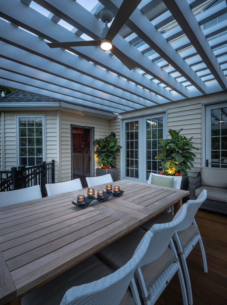 This is an example of a mid-sized mediterranean backyard deck in Philadelphia with a pergola.
