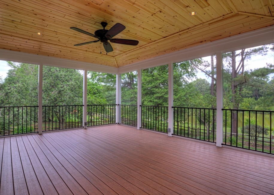Photo of an expansive traditional backyard screened-in verandah in DC Metro with decking and a roof extension.