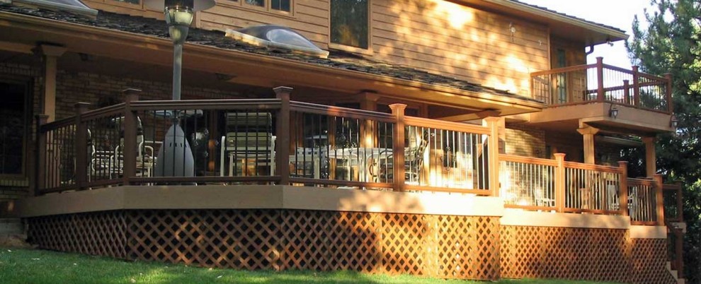 Inspiration for a large transitional backyard deck remodel in Denver with a roof extension